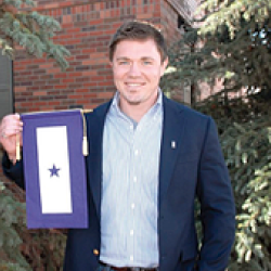 A man holding a framed award with a star.