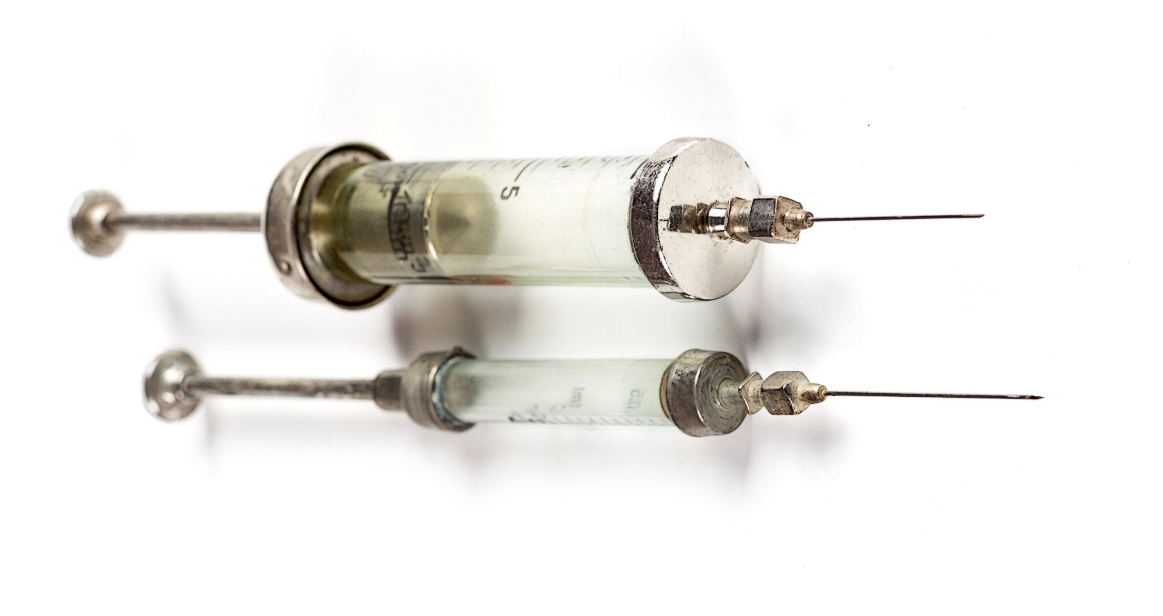 Vintage glass syringes with metal needles.