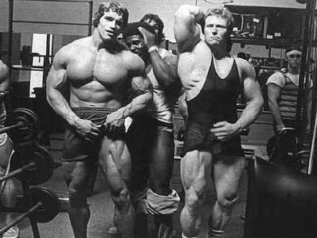 Bodybuilders posing in a gym together.